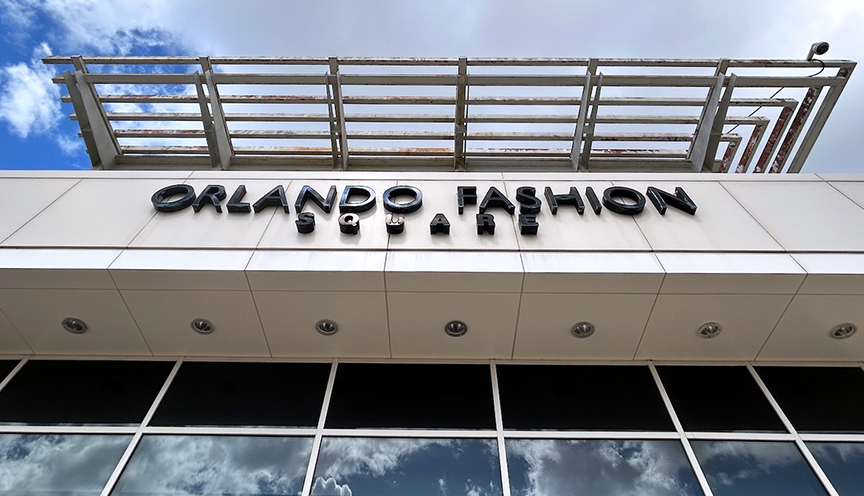 Orlando Fashion Square sign with sky reflecting in a window